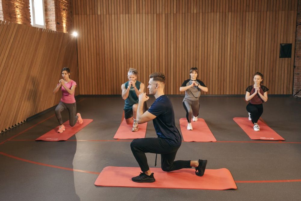 Small group coaching session with trainer guiding clients through simple movements